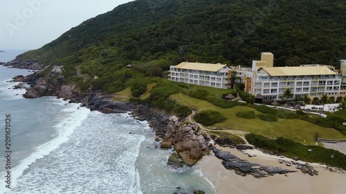 Scenic Coastal Village by the Sea with Rocky Cliffs, Green Landscape and Summer Sky