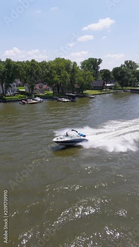 Aerial Vertical Shot Speedboat Flying Down River On Sunny Summer Day