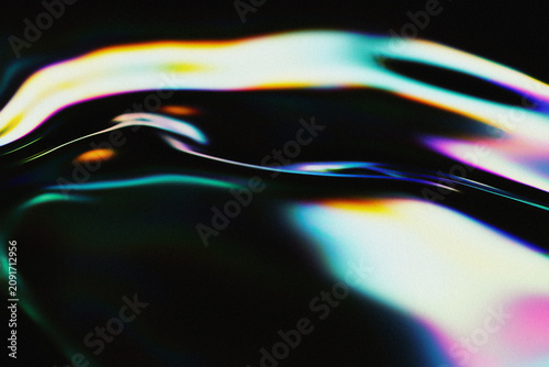 Abstract holographic liquid texture with iridescent rainbow gradient color reflections on black.