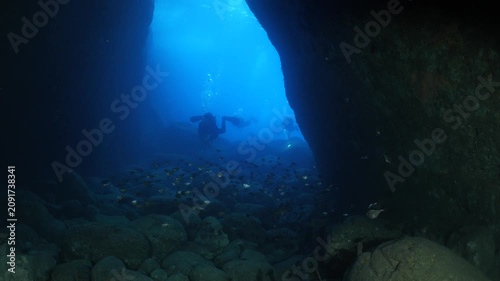 cave diving underwater scuba divers exploring caves and having fun ocean scenery sun beams and rays background