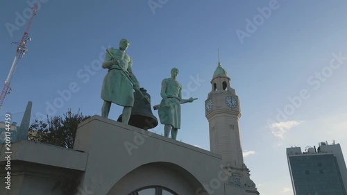 Statues and clock tower at historical square during afternoon light