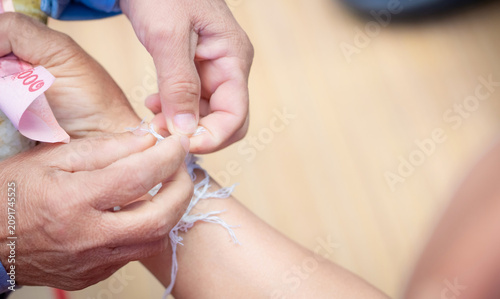 Tableau sur toile The ceremony of binding people’s wrist with the holy thread to console people's Kwan