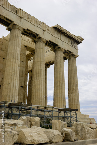The Parthenon in Athens, Greece, is undergoing restoration work, with scaffolding and large stone blocks visible in the foreground.