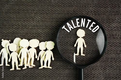 Foto Magnifier and miniature people with the word talented