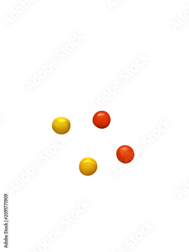Fotografía Four small round yellow and orange candy drops isolated on white background