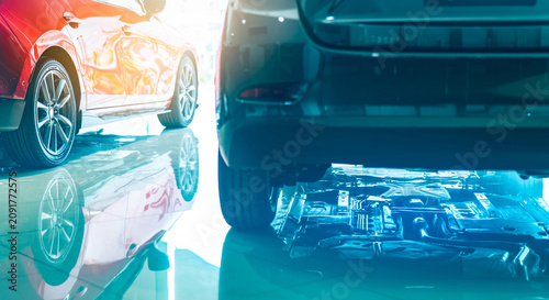 Obraz na plátne Closeup chassis, shaft, muffler of car reflected on shiny floor of showroom