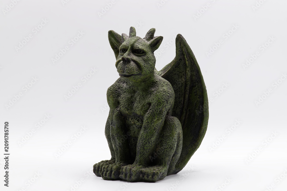 Fototapeta premium Green stone gargoyle statue with wings and horns isolated on a white background.