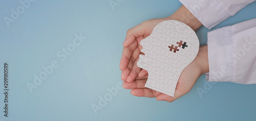 Foto Doctor hand holding paper head puzzle representing hopeful inclusive medical car