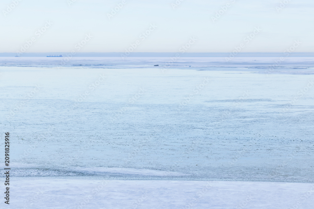 Naklejka premium A tranquil winter seascape showing a vast frozen sea and distant horizon in pale blue tones. Smooth ice, subtle texture and serene atmosphere convey cold, stillness and minimalist coastal beauty