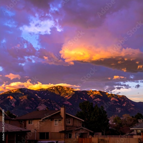Vibrant Sunset Clouds Glowing Over Mountain Range Above Suburban Neighborhood