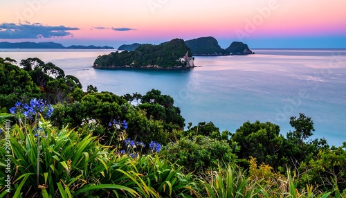 Lush Coastal Island Resting in Calm Blue Ocean at Pink Sunset Horizon