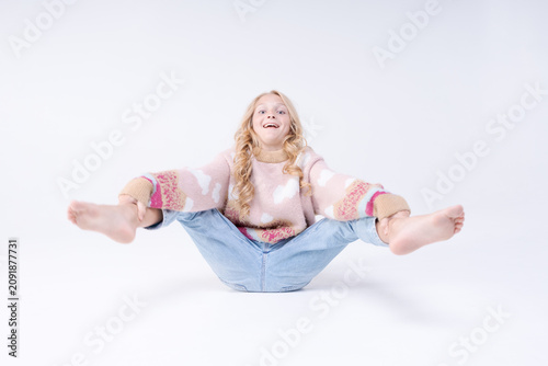Quadro su tela Caucasian Blonde Young Girl Sitting Hugging Knees Pouty Surprised Pose Pink Swea