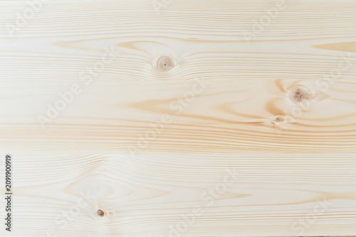 Fotografie A section of natural light pine wood board with knots and grain