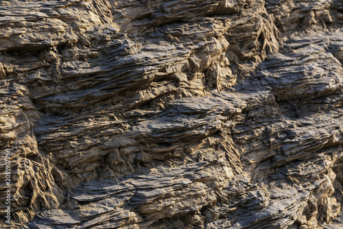Fotografía Detailed texture of grey layered slate rock face with horizontal stratification