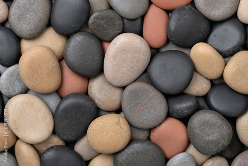 Macro shot of rounded wet river stones of various sizes and colors