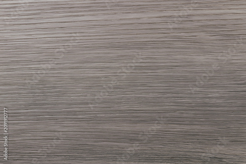 Close-up view of a dark grey wood grain texture with defined horizontal lines.