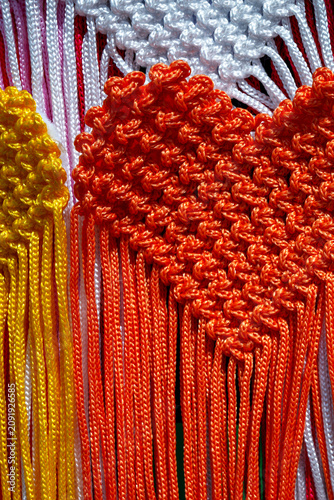 Colorful heart-shaped crafts made from yarn displayed at a local market