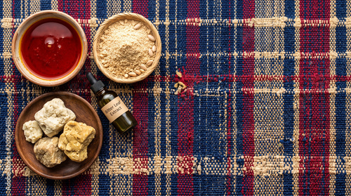 Top down view of Ghanaian raw shea butter and baobab oil on Kente cloth