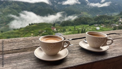 Quadro su tela Two cups of hot coffee on a wooden table with a scenic mountain view