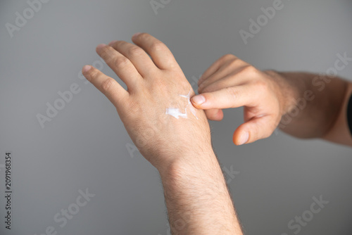 Obraz na plátně Man applying cream into hand.