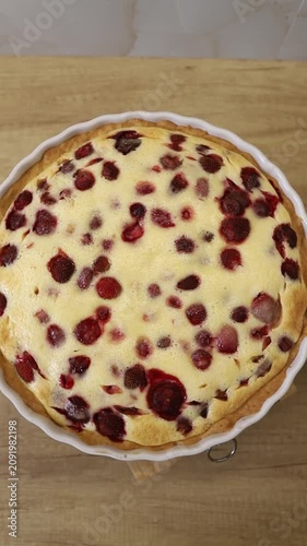 Delicious homemade berry pie in a white baking dish spinning on a kitchen counter top