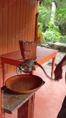 Unrecognizable man manually grinding toasted coffee beans
