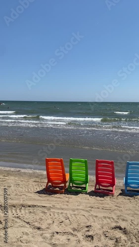 serie di sedie in plastica colorata in riva al mare