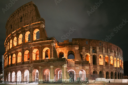 The illuminated Colosseum glows against the night sky in Rome, Italy