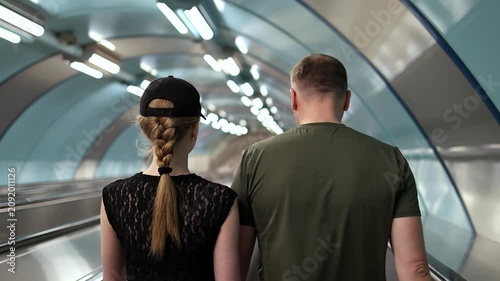 People walking into the subway, slow motion, view from behind.