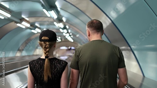 People walking into the subway, slow motion, view from behind.
