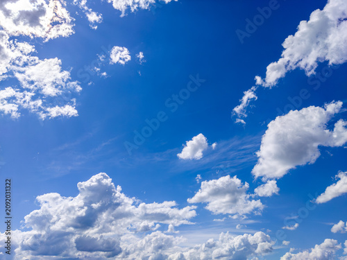 Fluffy white clouds drifting across blue sky