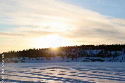 Golden Winter Sunset Above a Snow Covered Landscape and Forest