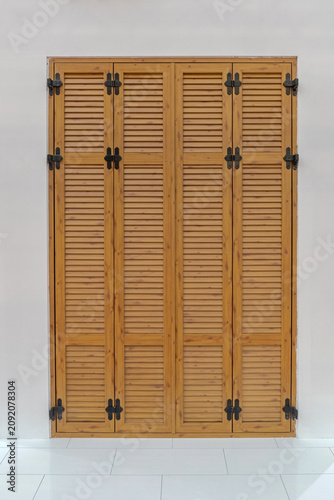 Closed Brown Wood Louvered Door Shutters at House