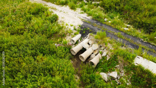 Tableau sur toile Aerial view of concrete drainage culvert pipes under a dirt road crossing surrou