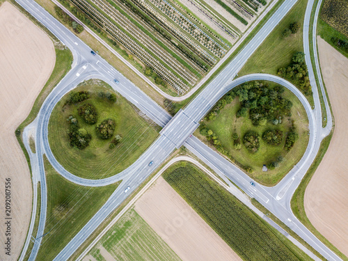 Tablou pe pânză Aerial view of a partial cloverleaf interchange in the countryside with trees and cultivated fields