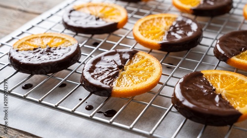 Chocolate covered orange slices, Citrus confection drying rack, Handmade dark chocolate fruit, Gourmet dessert close up, Premium food styling