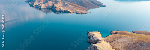 Принти на полотні Minimalist drone panorama of barren rocky islands surrounded by calm turquoise w
