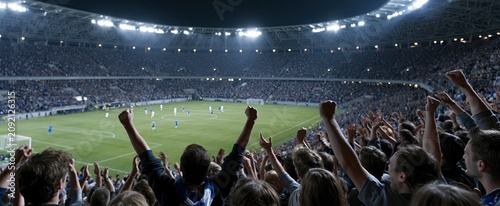 Brightly illuminated soccer stadium showcases dynamic players, enthusiastic crowd, and energetic ambiance during a major match.