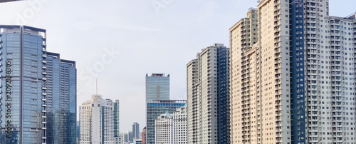 Perspective view of row of tall buildings with sky background for business and finance concept.
