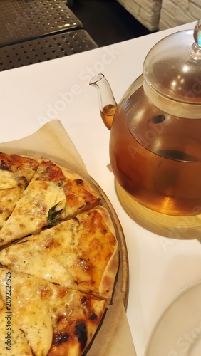 Restaurant food presentation featuring artisan pizza warm tea and inviting atmosphere Vertical layout created for pizzeria business branding social media advertising campaigns
