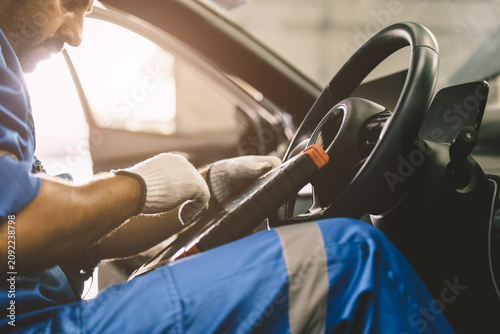 Professional mechanic using OBD2 scanner to inspect vehicle. Car diagnostic and maintenance service.