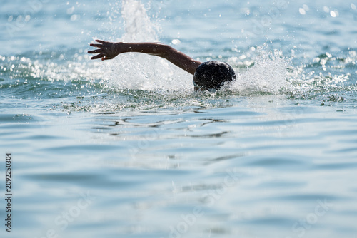 фотографія Teenage swimmer practicing freestyle crawl stroke in open ocean water during endurance training