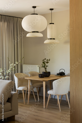 Modern Minimalist Dining Area with Elegant Hanging Lamps and Natural Light