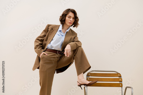 Принти на полотні Fashionable woman exudes confidence in elegant attire against a minimalist backd