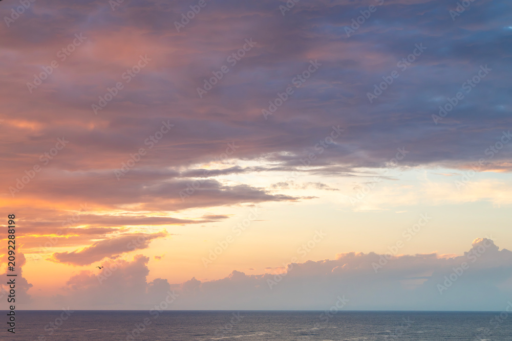 Fototapeta premium Colorful sunset over the sea with dramatic orange after rain clouds.