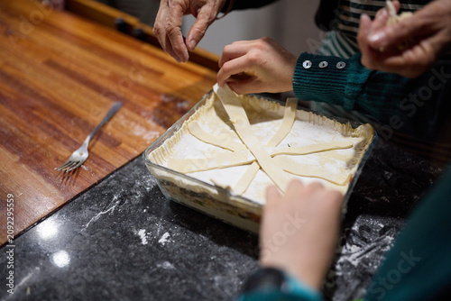 Grandmother and young girl baking together in a cozy home kitchen preparing a pastry