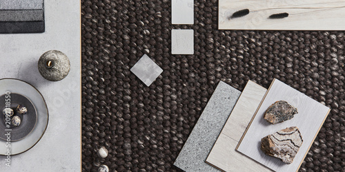 Stylish flat lay composition of architect moodboard with samples of building, brown textile and natural materials and personal accessories. Top view, template.