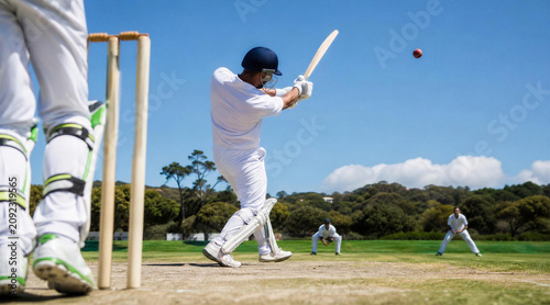 Cricket batter swinging bat on outdoor field