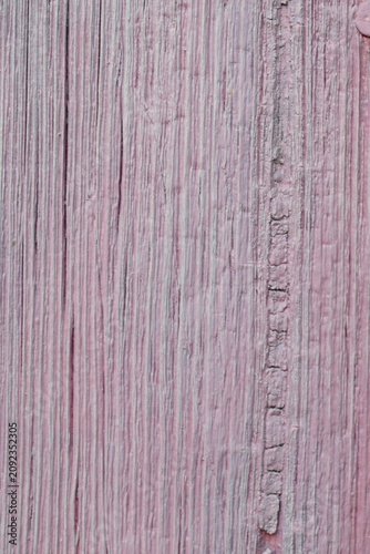 Wooden surface covered with a layer of pale pink paint. Visible traces of time, cracks.