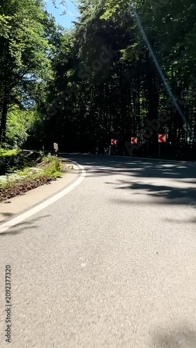 convertible car in sunny nature on a bright summer day. wide angle pursuit shot - vertical video for reels and story